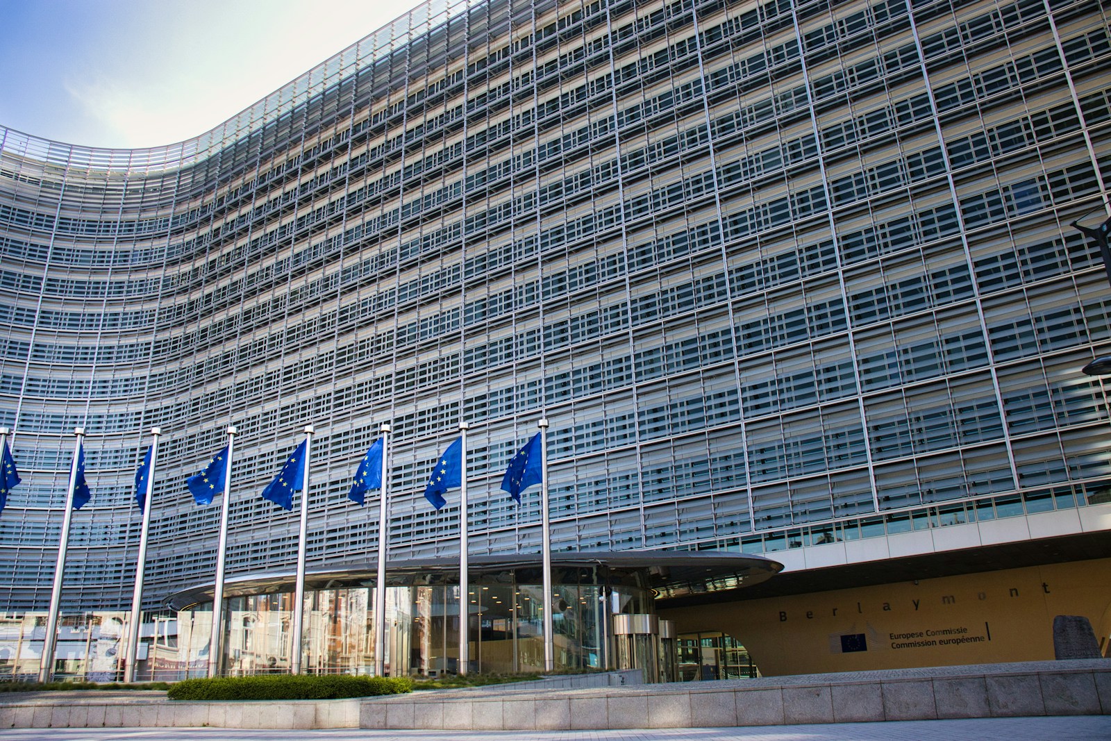 Modern glass building with european union flags